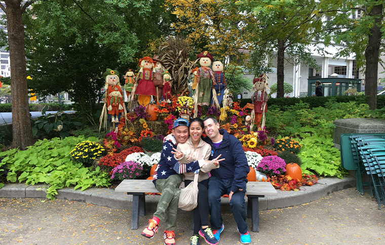 Three guests posing in front of an autumn-themed display